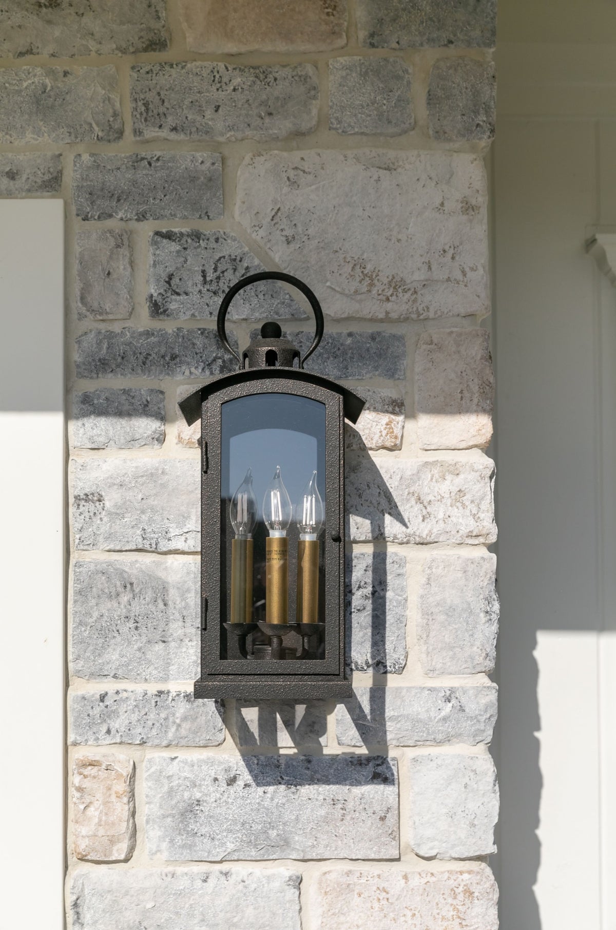 Chaplin exterior wall sconce on a stone wall at Alicia Torosian Design’s Windover project